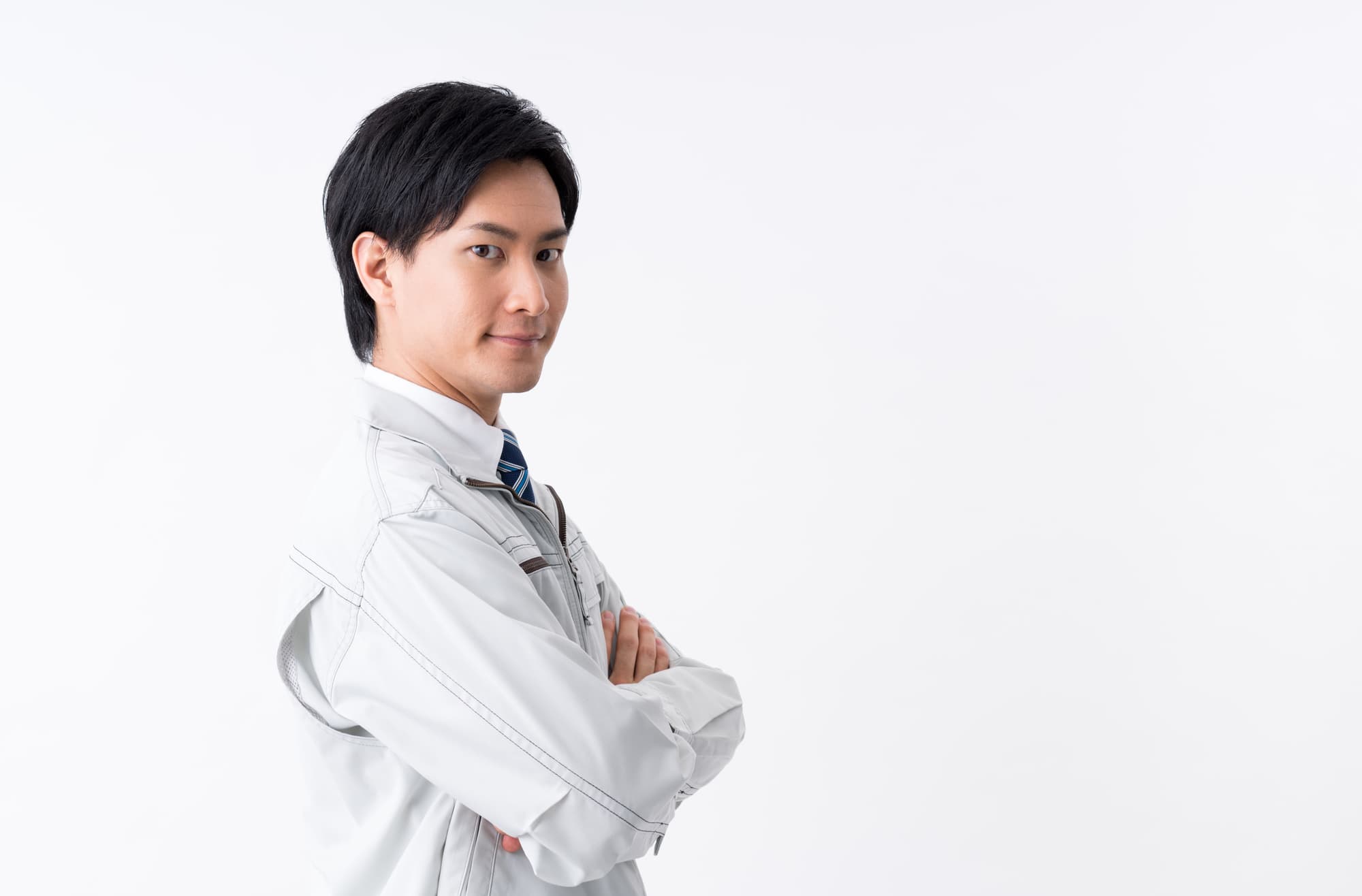 頼もしい眼差しをこちらに向け腕組をする作業着姿の男性
